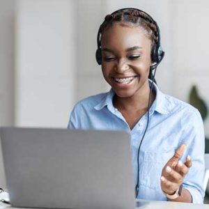 Online Algebra Tutors. Black Female Tutor In Headset Having Video Conference With Laptop