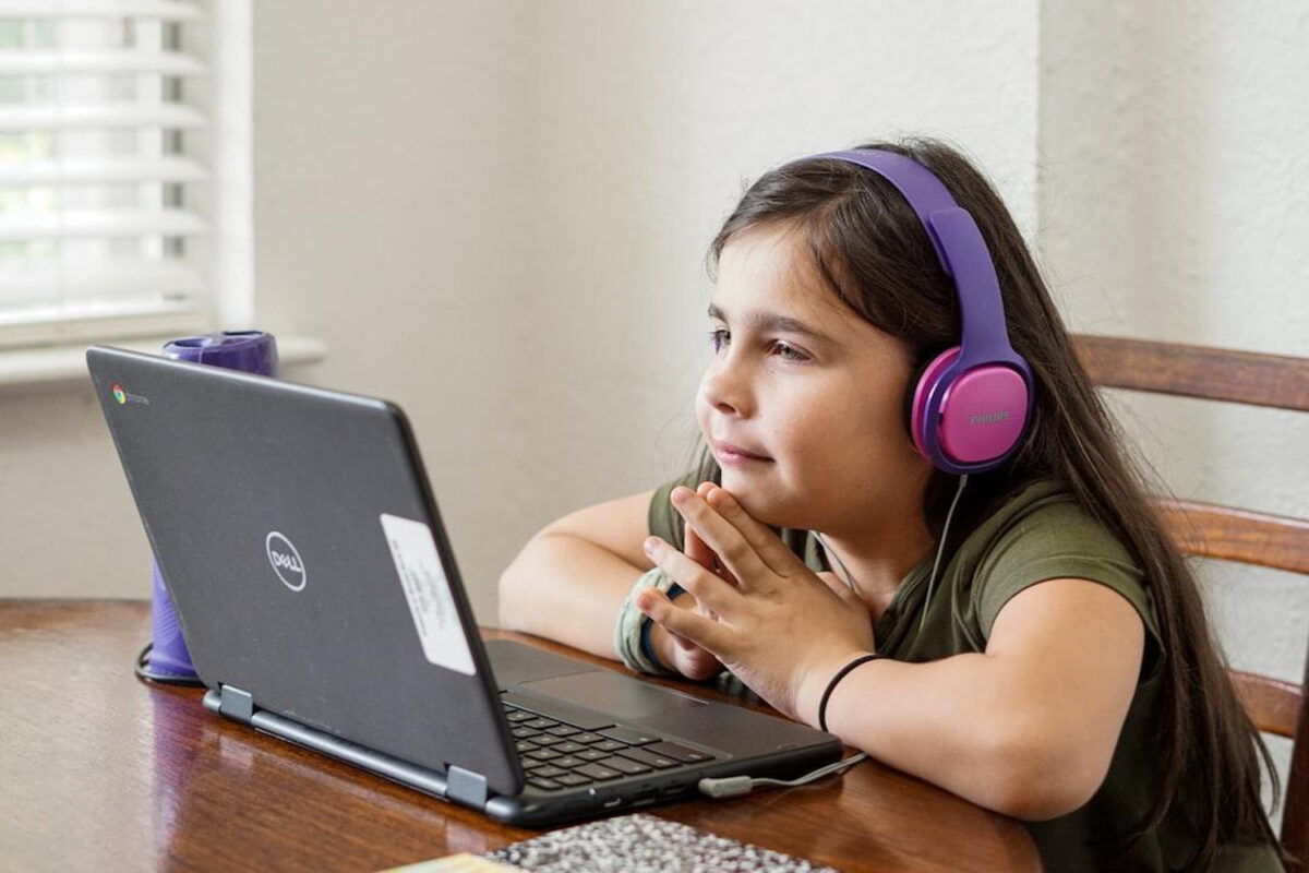 girl with headphones in front of laptop