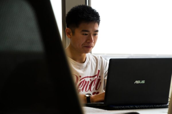 A student studying with a math tutor on his laptop.