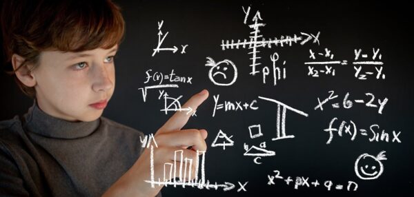 A young student points at math equations on a board.