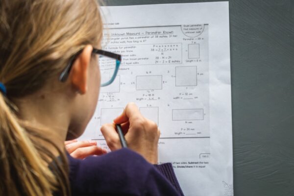 Student solving a worksheet focused on 10th Grade Math Essentials problems