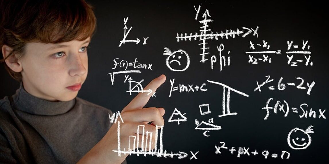 A young student points at math equations on a board.
