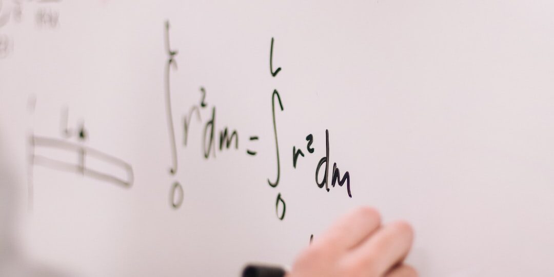A closeup of a student working on math problems on a whiteboard.