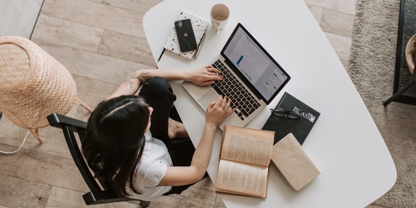 Person at desk with computer and books